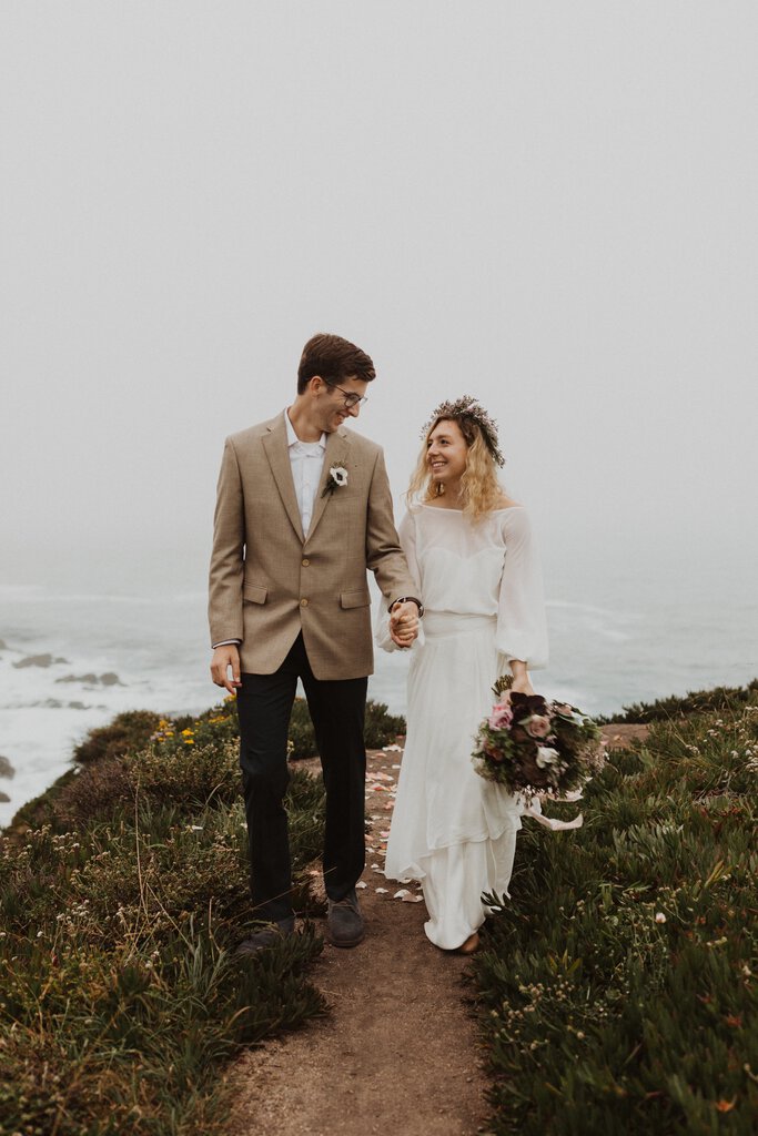 Madison + Kanyon bride and groom walk by the coast in California.