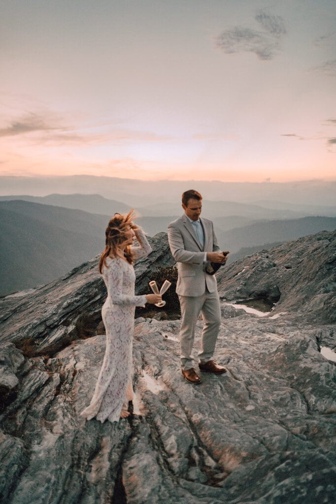 monica leavell photo linville gorge wilderness north carolina adventure elopement 046 couple pops champagne bottle.