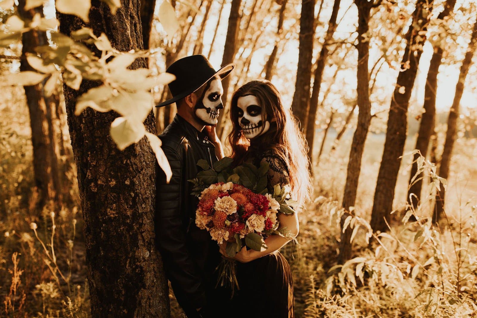 couple in woods embracing in skeleton makeup.