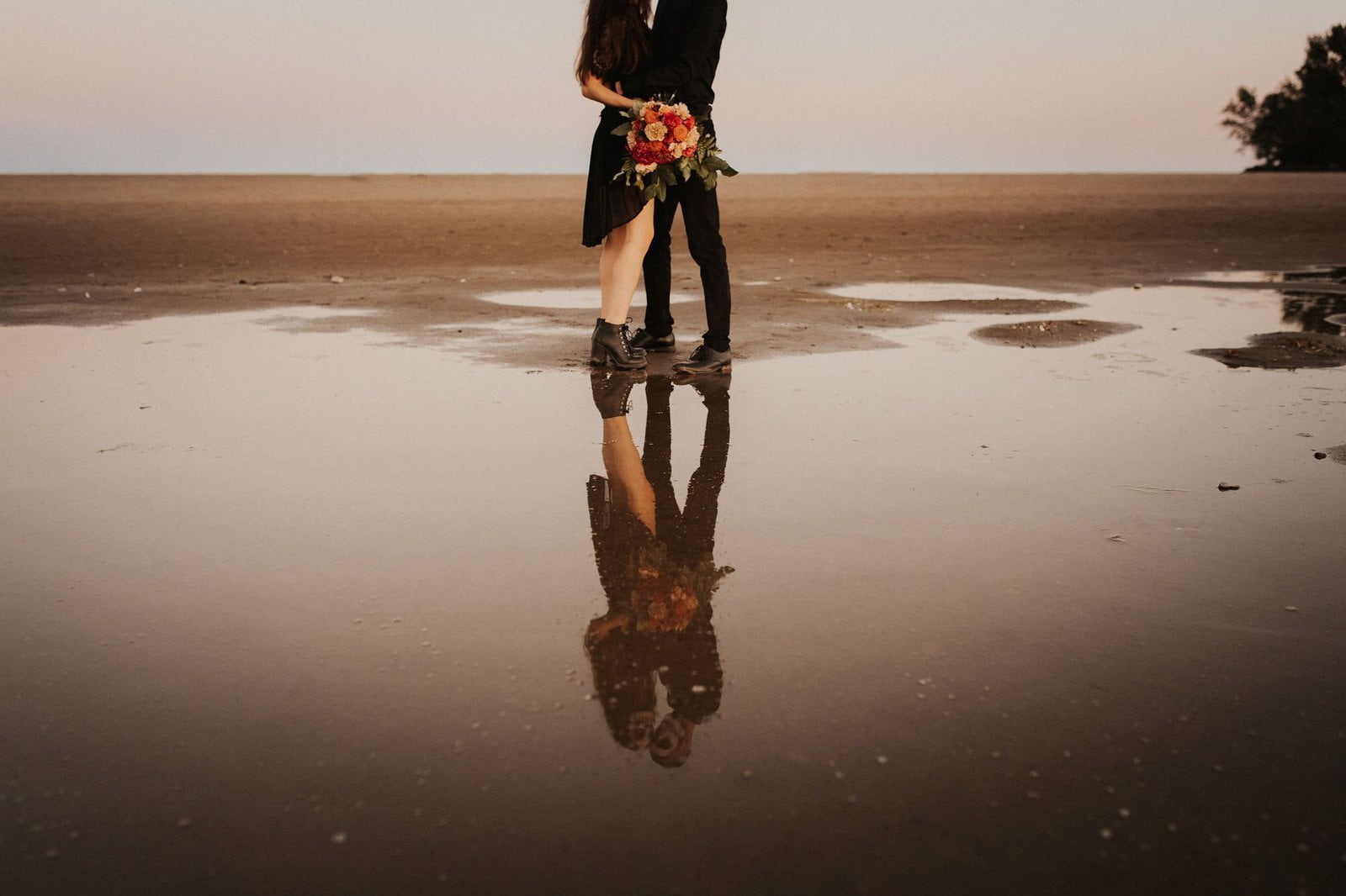 reflection shot of couple on beach.