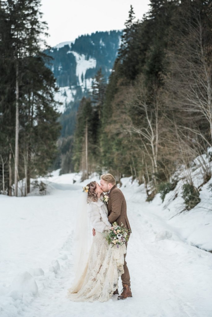 Bride and groom share a kiss for winter elopement.