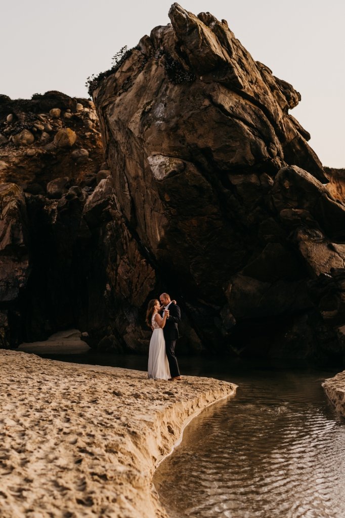 bride and groom by cave in California