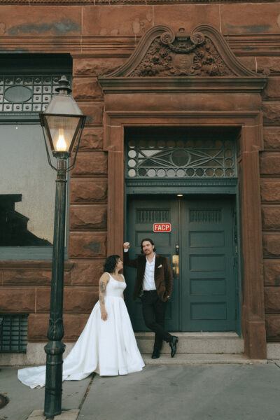 Bride and groom posing for elopement photos on the downtown streets of New Bedford, MA. Photo by Rhode Tripper Photography.