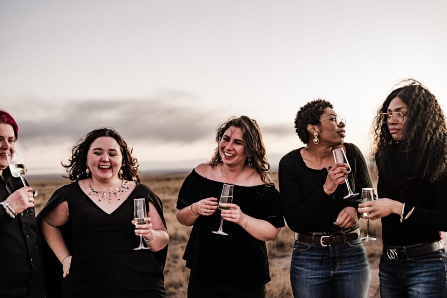 After their intimate ceremony, the couple shares a celebratory moment with friends, champagne in hand, in the heart of the Painted Desert.