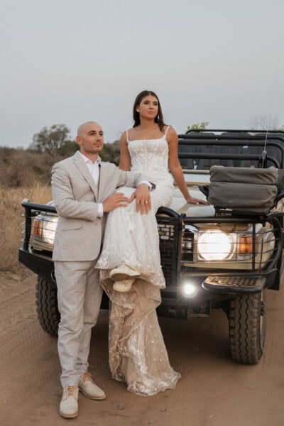 Editorial-style safari elopement couple seated on front of their safari vehicle at Klaserie Drift Safari Camp in Hoedspruit.