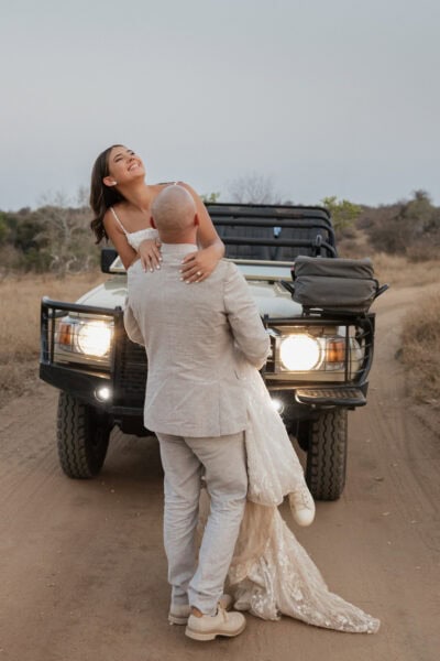 Bride and groom dancing in front of a safari vehicle under the African sunset at Klaserie Drift Safari Camp.