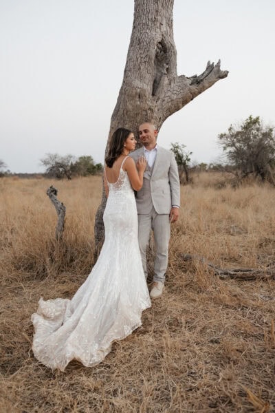Bride and groom share an intimate moment while leaning back against a tree during their safari elopement in South Africa.