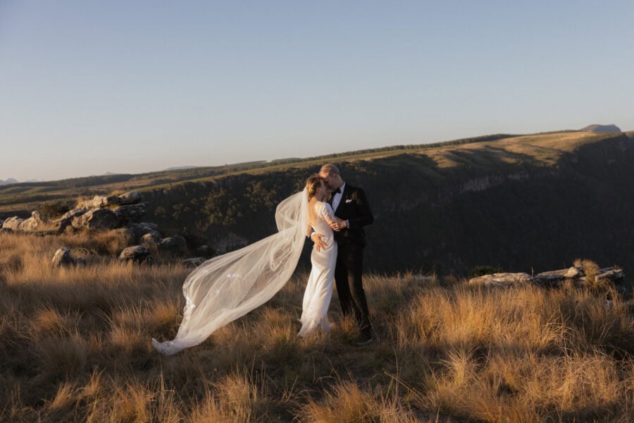 Bride’s veil catching the breeze as the couple shares an intimate moment on the Blyde Canyon escarpment overlooking the Lowveld.