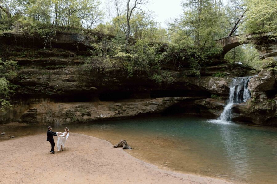 Couple dancing on the shore next to the Old Man's Cave waterfall.